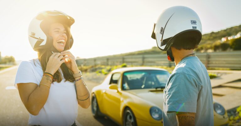 Pilote et passager casqués à côté d'une Porsche jaune lors d'un stage de pilotage My Driving Experience