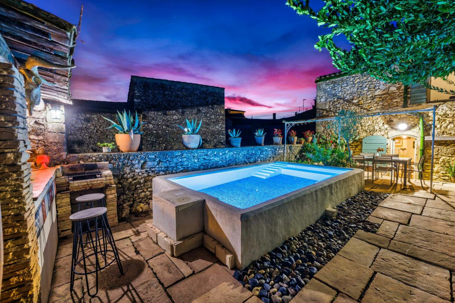 Terrasse avec piscine éclairée à l'heure bleue, photographe immobilier à Montpellier