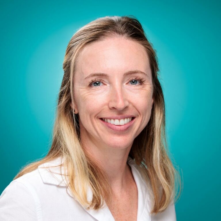 Portrait corporate d'une femme blonde souriante sur fond turquoise