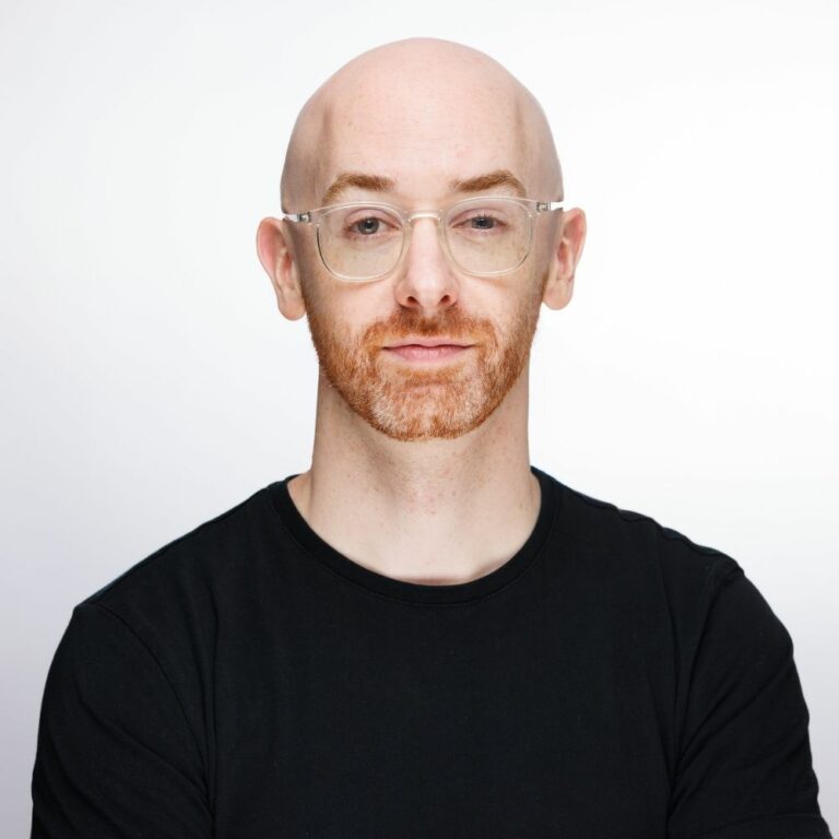 Portrait corporate de Gaëtan Hamel, lunettes et barbe rousse, sur fond blanc