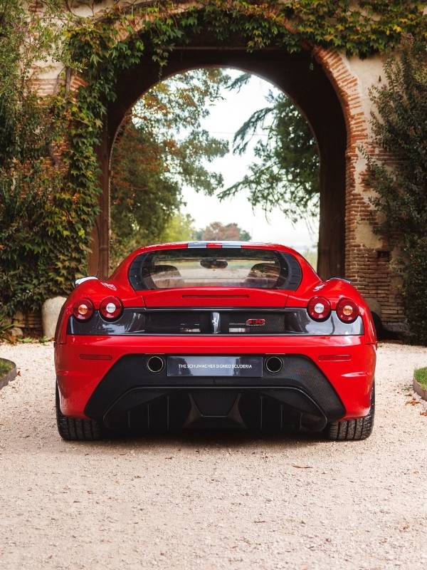 Ferrari F430 Scuderia rouge vue de l'arrière sous une arche en pierre couverte de végétation, photographe automobile à Montpellier