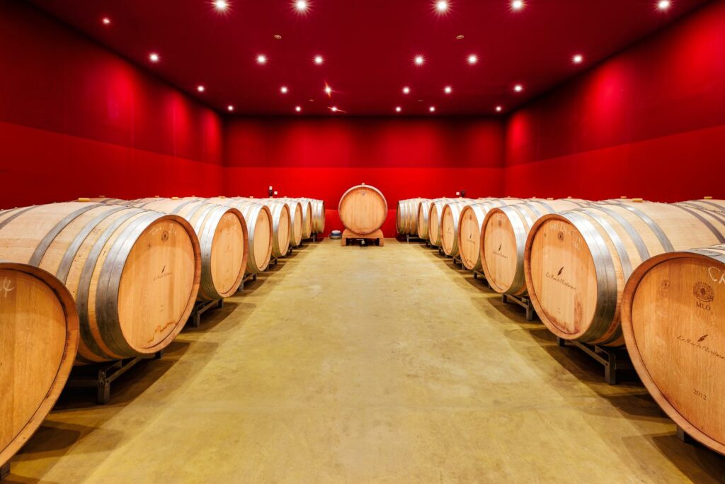 Chai à barriques aux murs rouges du Mas de l’Écriture