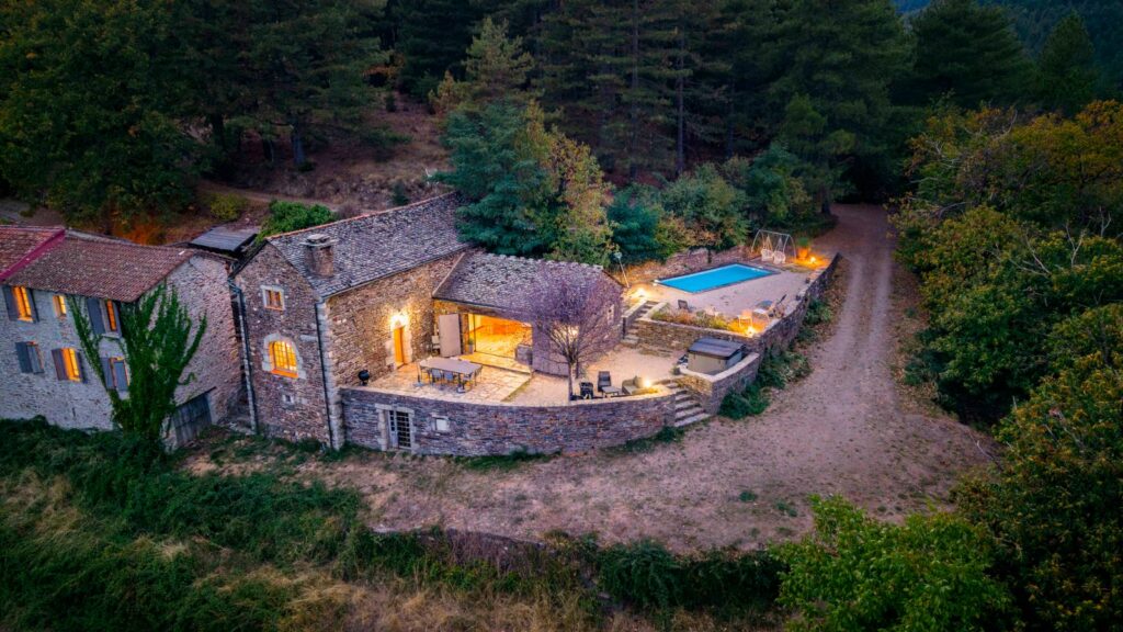 Photographe immobilier dans les Cévennes : domaine de deux mas cévenols à Génolhac au crépuscule, vue drone