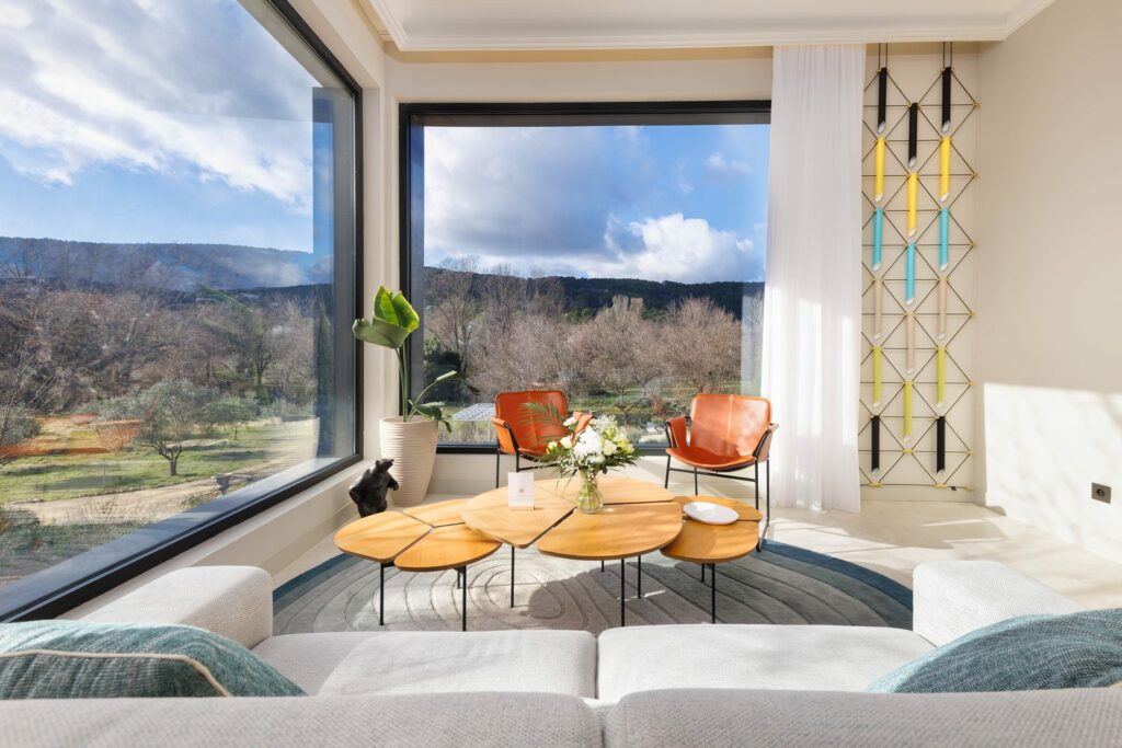 Salon du château Pimo avec grande baie vitrée ouverte sur la colline