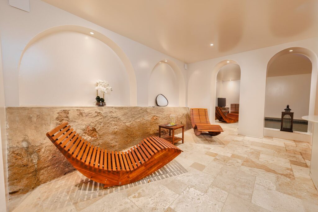 Spa voûté du château Pimo avec transats en bois et murs en pierre