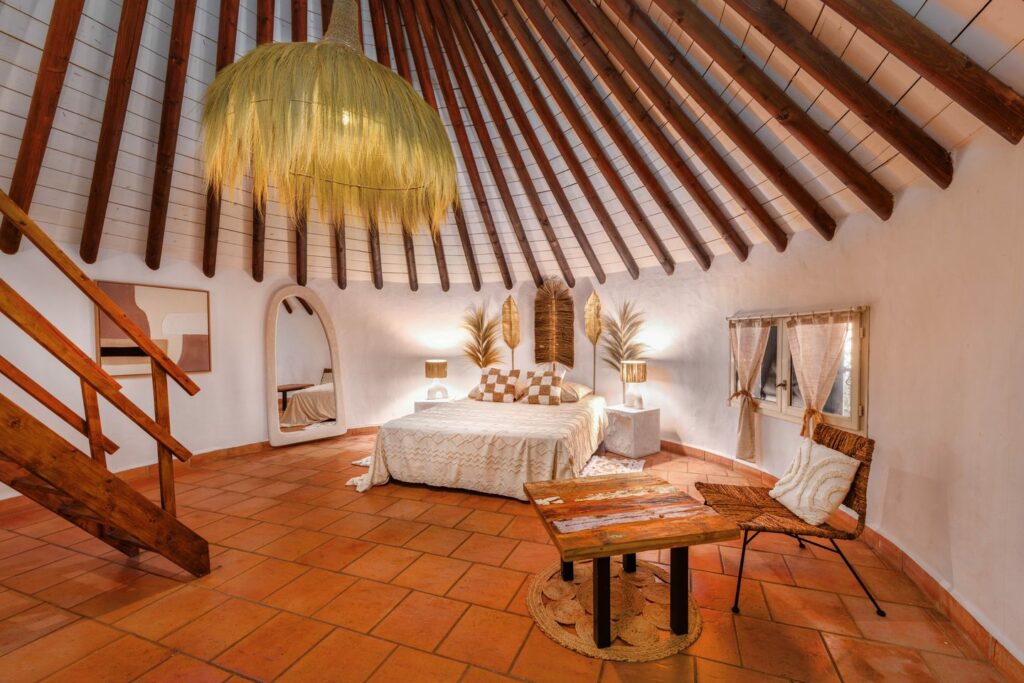 Chambre sous charpente apparente avec lustre et escalier, domaine à Vestric-et-Candiac