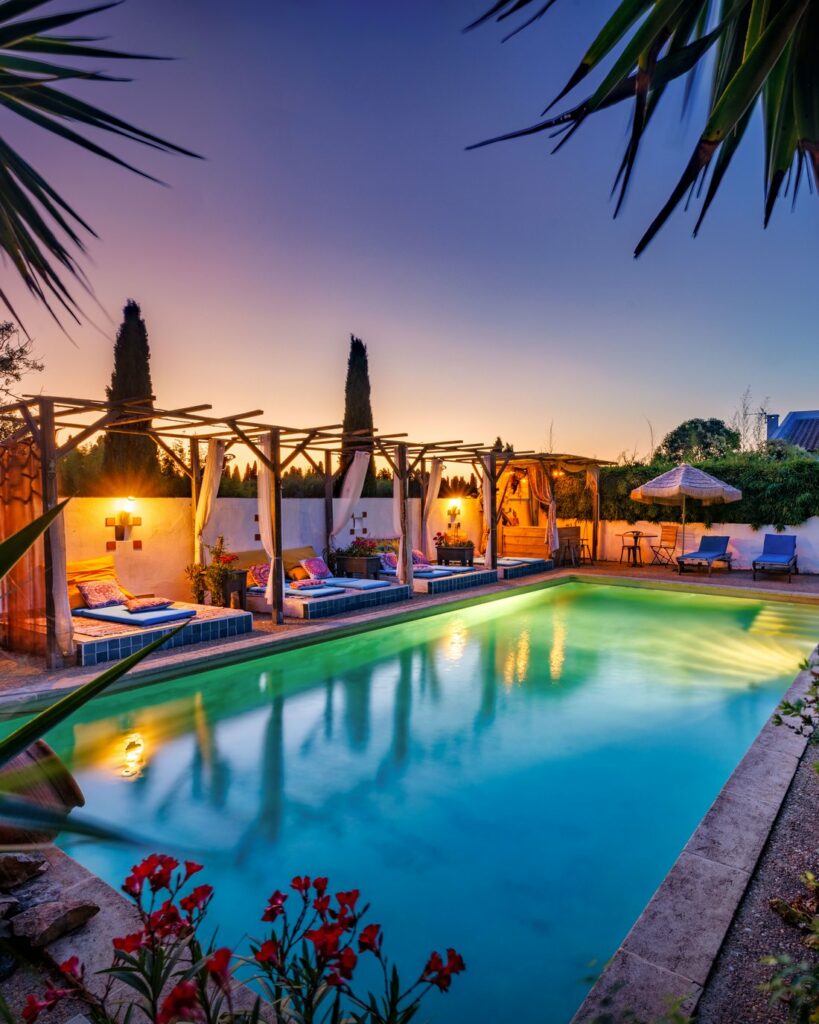 Villa avec piscine éclairée au crépuscule, pergolas et palmiers, domaine à Vestric-et-Candiac